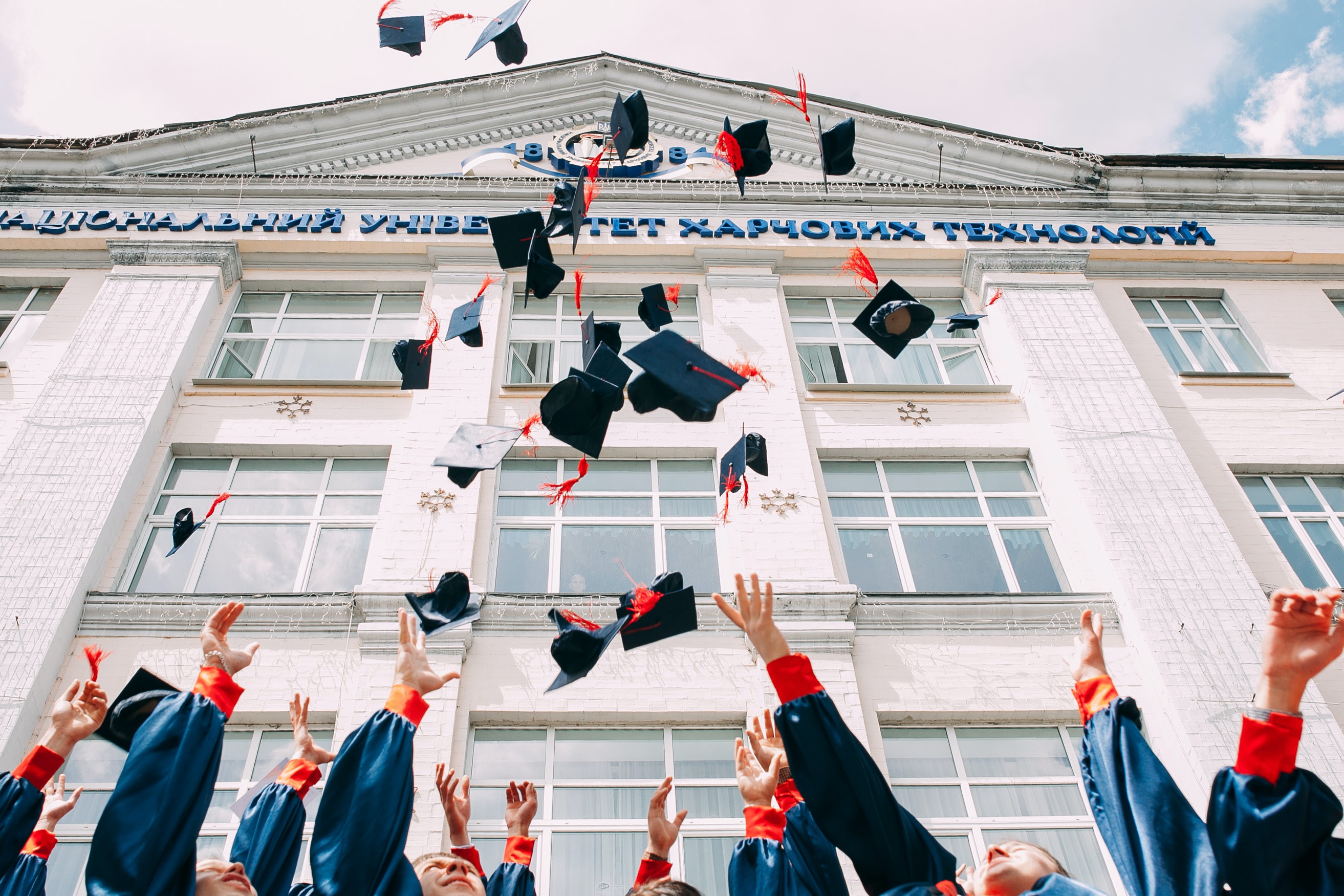 Graduates throwing toga hats in the air